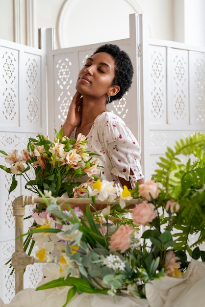 Free photo side view woman posing with flowers