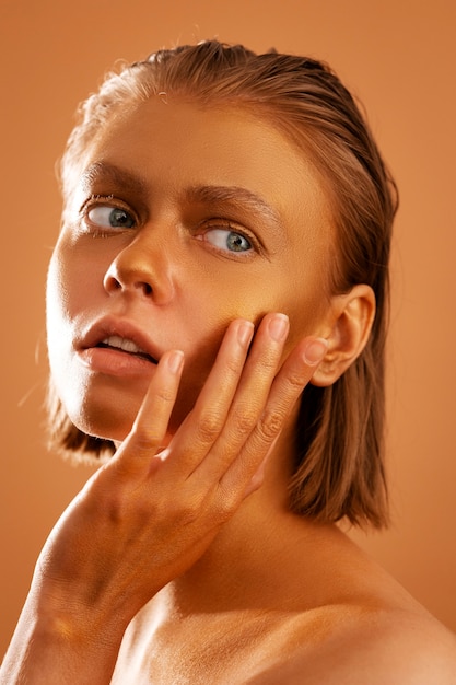 Free photo side view woman posing with gold body painting