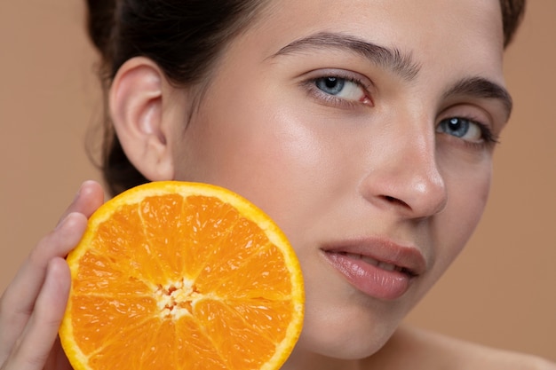 Side view woman posing with orange slice