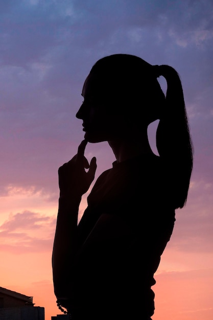 Free photo side view woman posing with sky background