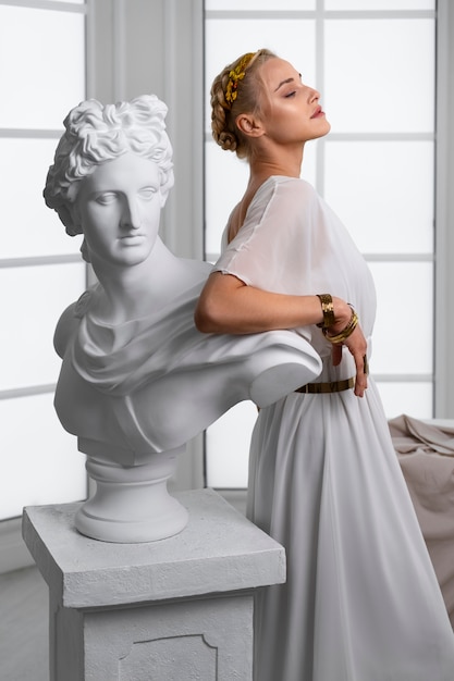 Side view woman posing with statue