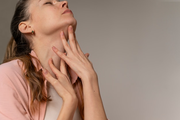 Free photo side view woman practicing facial yoga