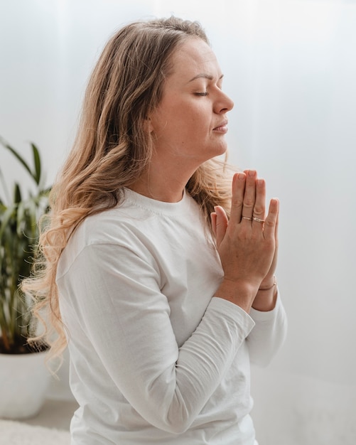 Free photo side view of woman praying