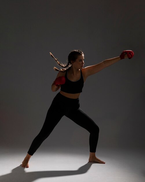 Side view woman punching with box gloves