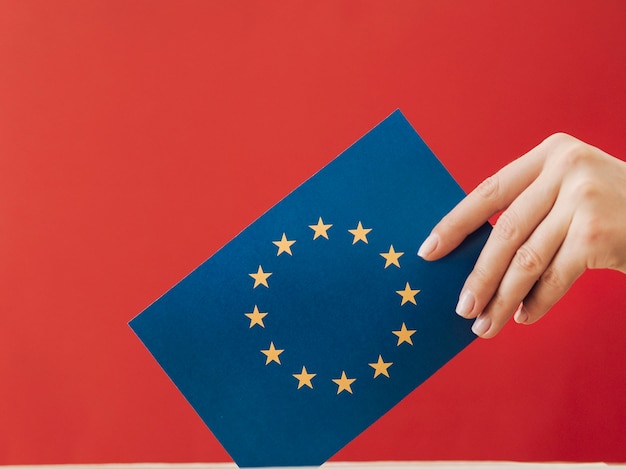 Free Photo side view woman putting an european voting card in a box 