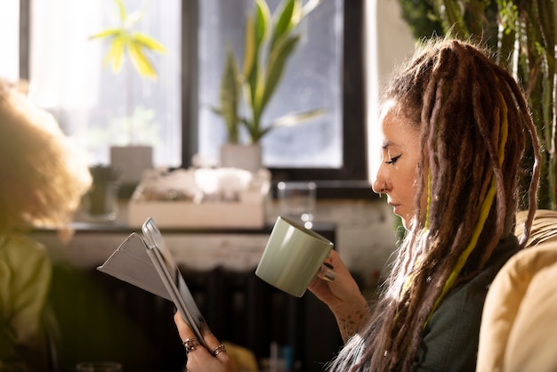 Free photo side view woman reading on tablet