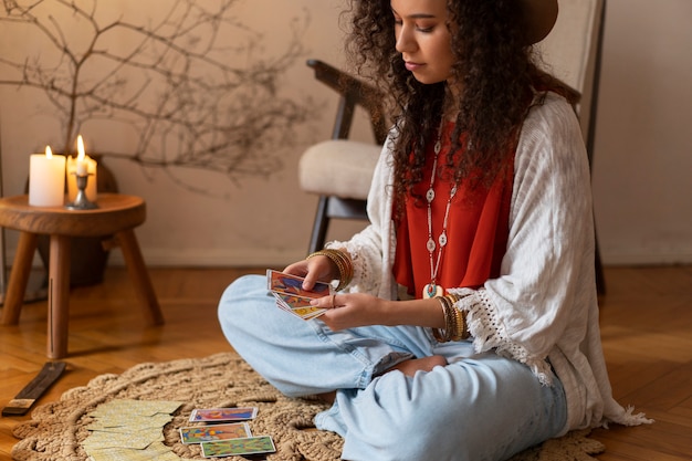 Free photo side view woman reading tarot