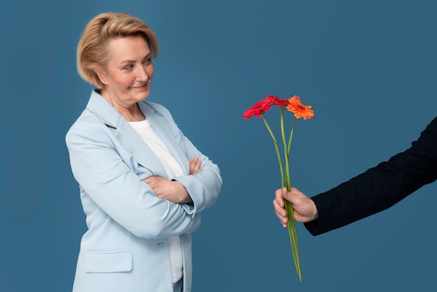 Free photo side view woman receiving flowers