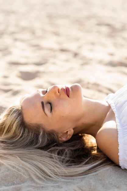 Side view of woman relaxing on beach sands