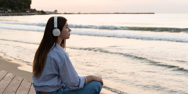 Side view woman relaxing on the beach with copy space