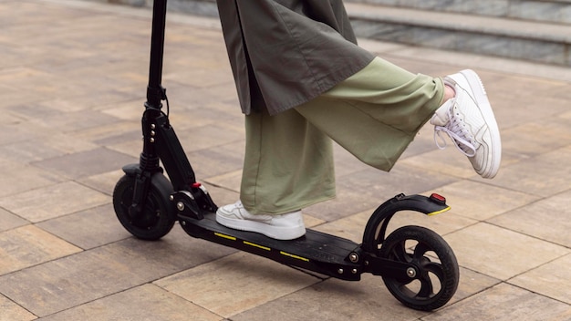 Side view of woman riding her electric scooter outdoors