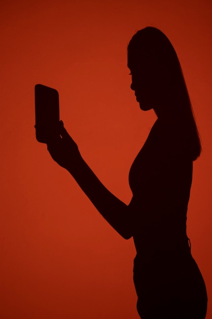 Free photo side view woman's shadow holding smartphone