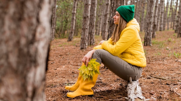 Side view woman sitting in the forest