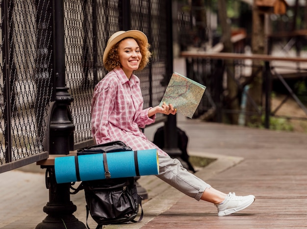 Free photo side view woman sitting while holding a map