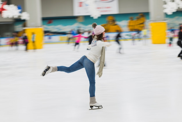 Side view woman skating on rink