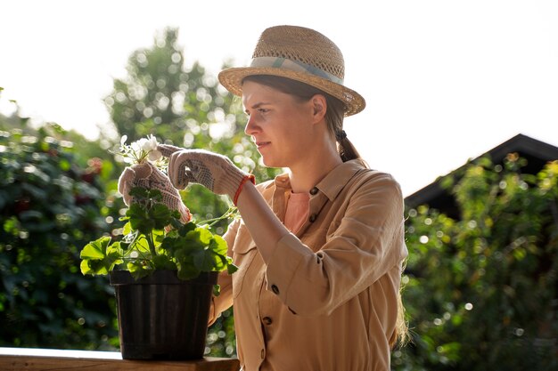 Side view woman taking care of plant outdoors