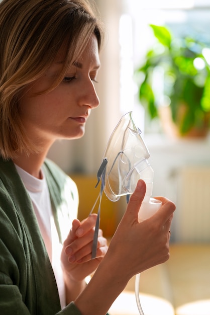 Free Photo side view woman using nebulizer