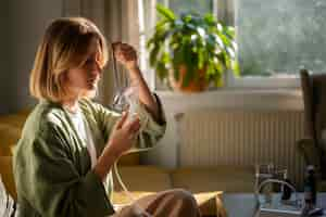 Free photo side view woman using nebulizer