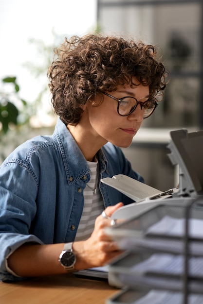 Free photo side view woman using printer