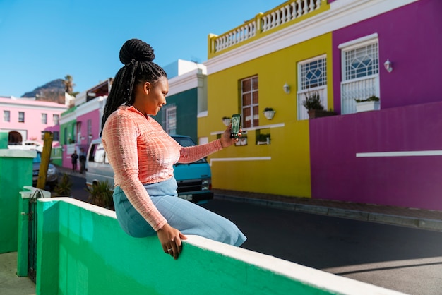 Free photo side view woman using smartphone outdoors