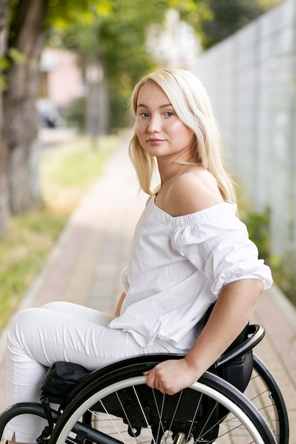 Free photo side view of woman in wheelchair outdoors