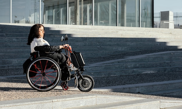 Side view of woman in a wheelchair on the street with copy space