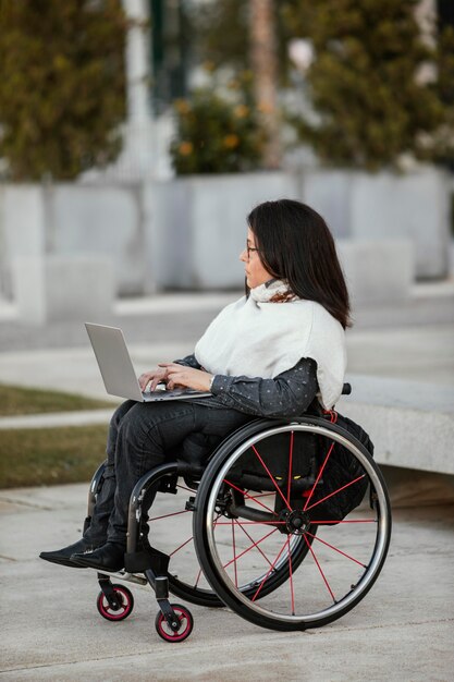 Side view of woman in a wheelchair with laptop