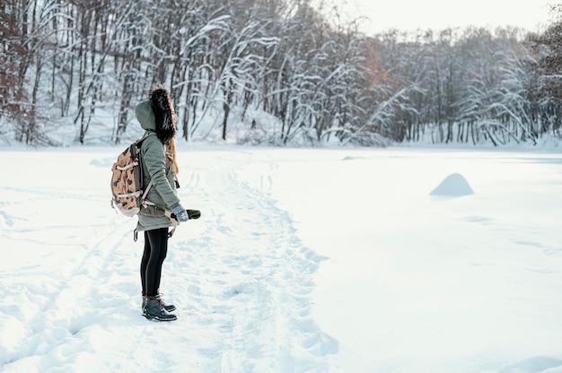 Side view woman with backpack on winter day