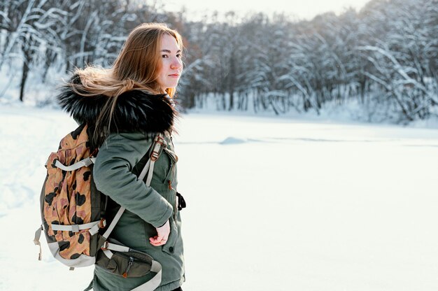 Side view woman with backpack on winter day