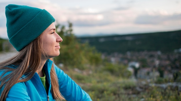 Free Photo side view woman with beanie enjoying the view