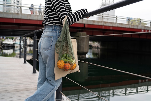 Free Photo side view woman with fabric bag