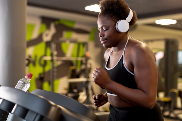 Side view woman with headphones running