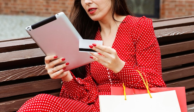 Side view of woman with laptop and credit card purchasing online