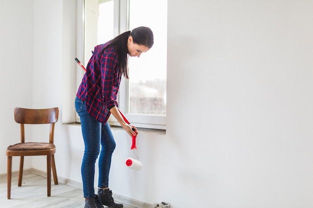 Free photo side view woman with paint rollers