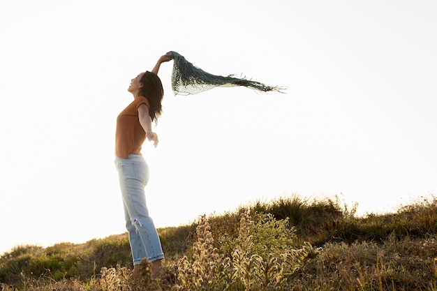 Free Photo side view of woman with scarf outdoors