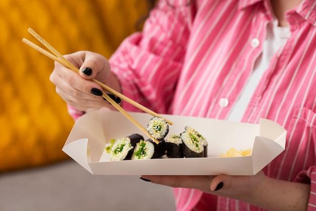 Free photo side view woman with sushi