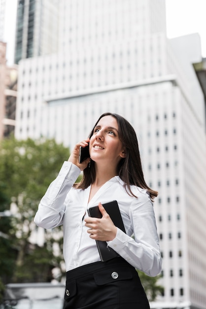 Free photo side view woman with tablet talking on the phone