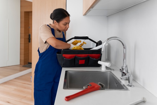 Free photo side view woman working as plumber