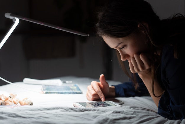 Side view woman working in dark bedroom.