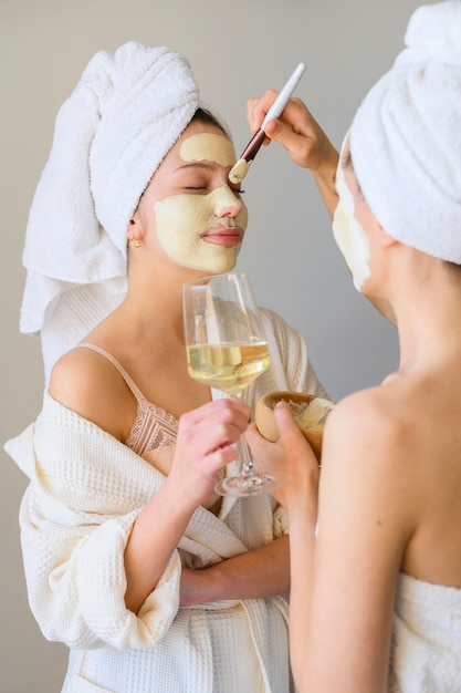 Side view of women applying face masks at home