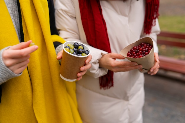 Free Photo side view women holding berries