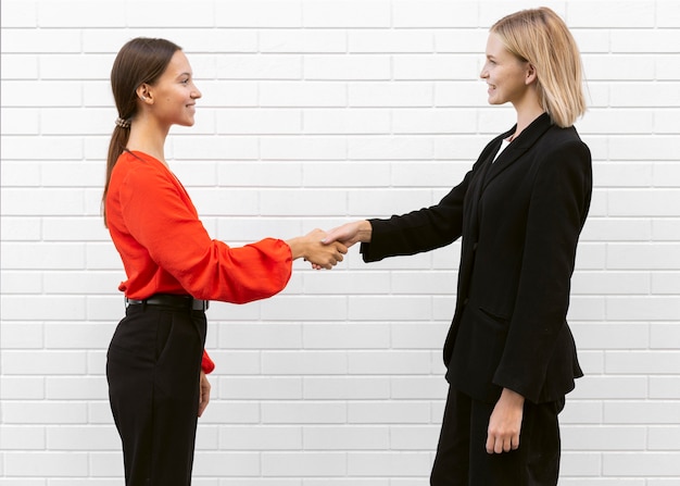 Side view of women saluting each other