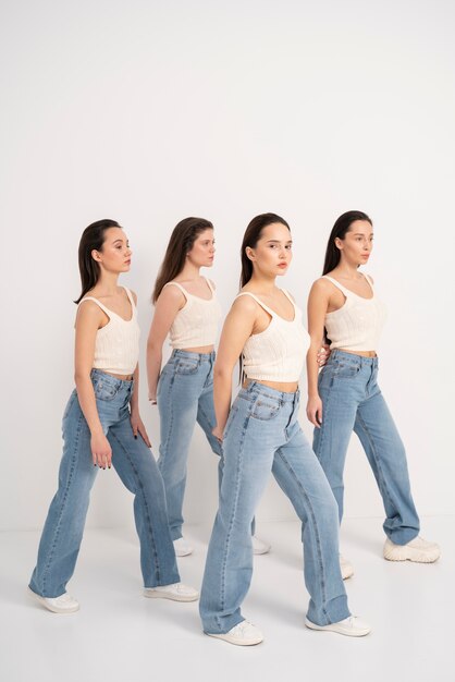 Side view of women in tank tops and jeans posing in minimalist portraits