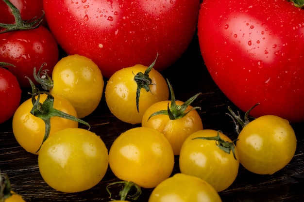 Side view of yellow and red tomatoes on wooden surface