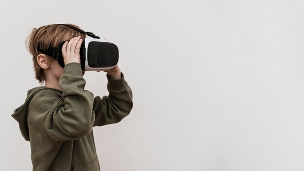 Side view of young boy using virtual reality headset with copy space