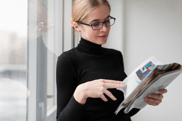 Free photo side view young female reading magazine