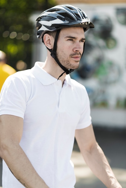 Free photo side view of young male cyclist with protective helmet