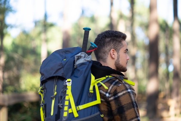 Free Photo side view of young male hiker. caucasian man with beard and big backpack. hobby, nature concept