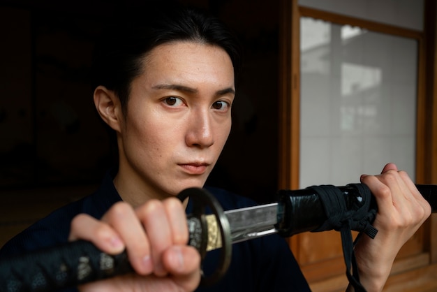 Side view young man holding sword