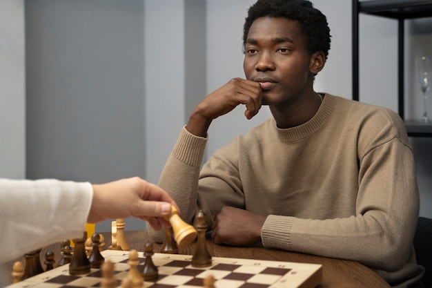 Side view young man playing chess